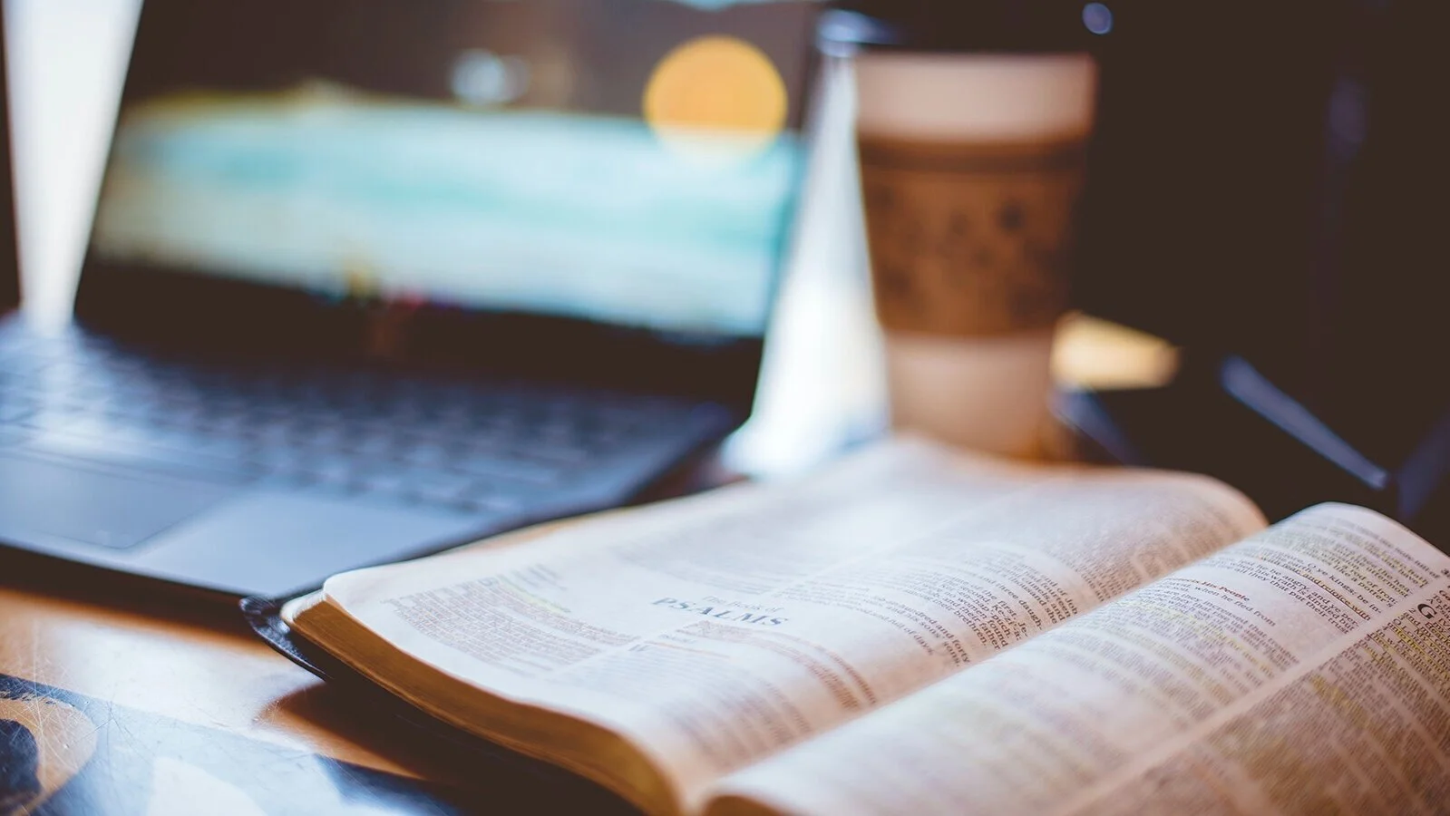 open Bible next to laptop