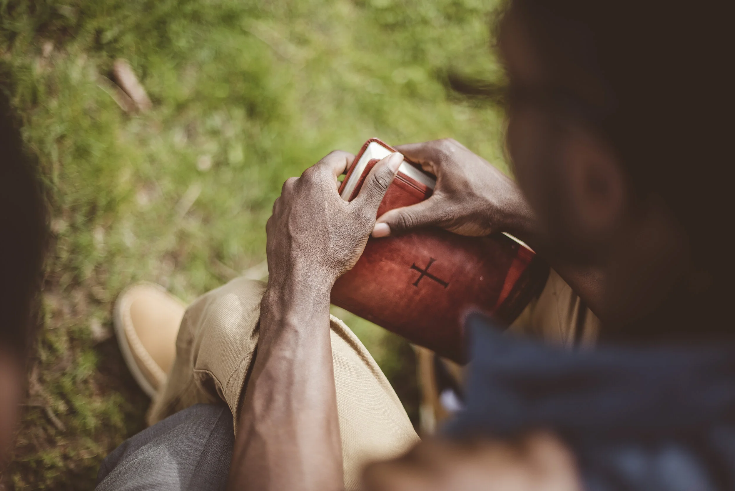 man holding Bible outdoors