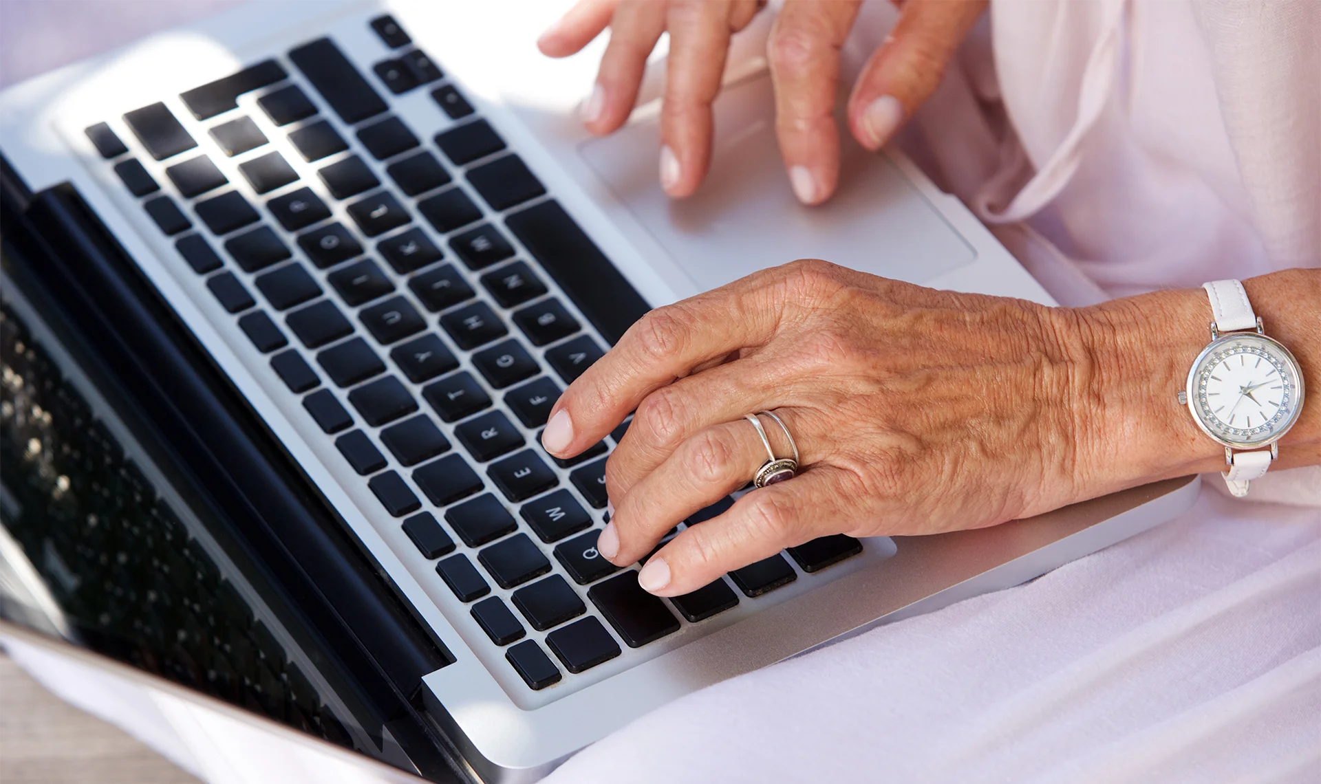 retiree using laptop tp review financial newsletters