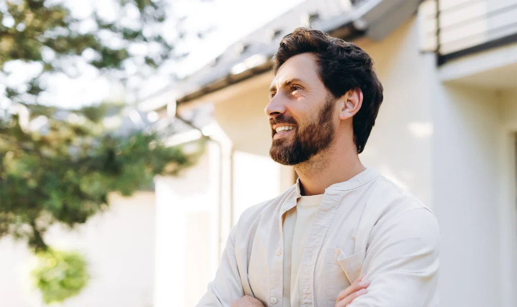 smiling credentialed pastor standing outside his house
