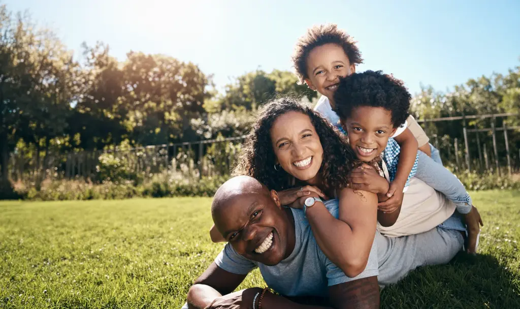 happy family smiling and laughing outside on grass
