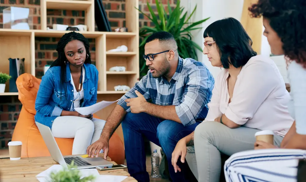 Group discussing financial planning in a modern office using laptop