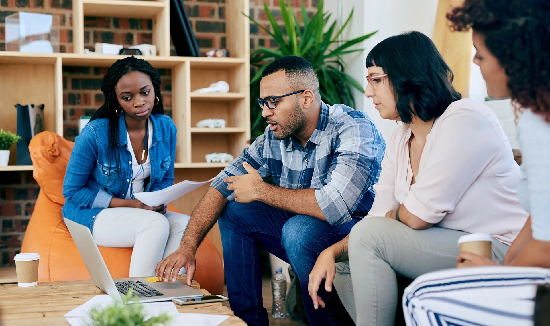 Group discussing financial planning in a modern office using laptop